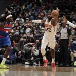 
              Phoenix Suns' Deandre Ayton (22) hits the ball as Washington Wizards' Montrezl Harrell (6) and Kentavious Caldwell-Pope, left, defend during the first half of an NBA basketball game, Saturday, Feb. 5, 2022, in Washington. (AP Photo/Luis M. Alvarez)
            