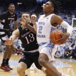 
              North Carolina's Caleb Love (2) drives around Louisville's Jarrod West (13) during the first half of an NCAA college basketball game in Chapel Hill, N.C., Monday, Feb. 21, 2022. (Ethan Hyman/The News & Observer via AP)
            