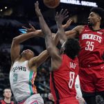 
              San Antonio Spurs forward Keldon Johnson (3) is fouled as he drives to the basket against Houston Rockets forward Jae'Sean Tate (8) and center Christian Wood (35) during the second half of an NBA basketball game Friday, Feb. 4, 2022, in San Antonio. (AP Photo/Eric Gay)
            