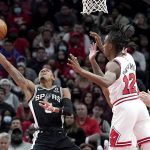 
              San Antonio Spurs' Dejounte Murray, left, shoots past Chicago Bulls' Ayo Dosunmu (12) during the second half of an NBA basketball game Monday, Feb. 14, 2022, in Chicago. (AP Photo/Charles Rex Arbogast)
            