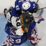 
              Germany's Yasin Ehli, center, collides with United States goalkeeper Drew Commas, down, and United States' Aaron Ness during a preliminary round men's hockey game between United States and Germany at the 2022 Winter Olympics, Sunday, Feb. 13, 2022, in Beijing. (AP Photo/Petr David Josek)
            