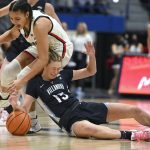
              Connecticut's Azzi Fudd and Villanova's Brooke Mullin, right, collide while chasing a loose ball in the second half of an NCAA college basketball game, Wednesday, Feb. 9, 2022, in Hartford, Conn. (AP Photo/Jessica Hill)
            