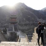 
              A video journalist covering the 2022 Winter Olympics, works on a trip to the Juyongguan section of the Great Wall, Wednesday, Feb. 9, 2022, on the outskirts of Beijing. (AP Photo/Chisato Tanaka)
            