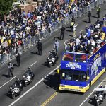 
              Buses carrying Los Angeles Rams players and coaches drive past fans during the team's victory parade in Los Angeles, Wednesday, Feb. 16, 2022, following their win Sunday over the Cincinnati Bengals in the NFL Super Bowl 56 football game. (AP Photo/Kyusung Gong)
            