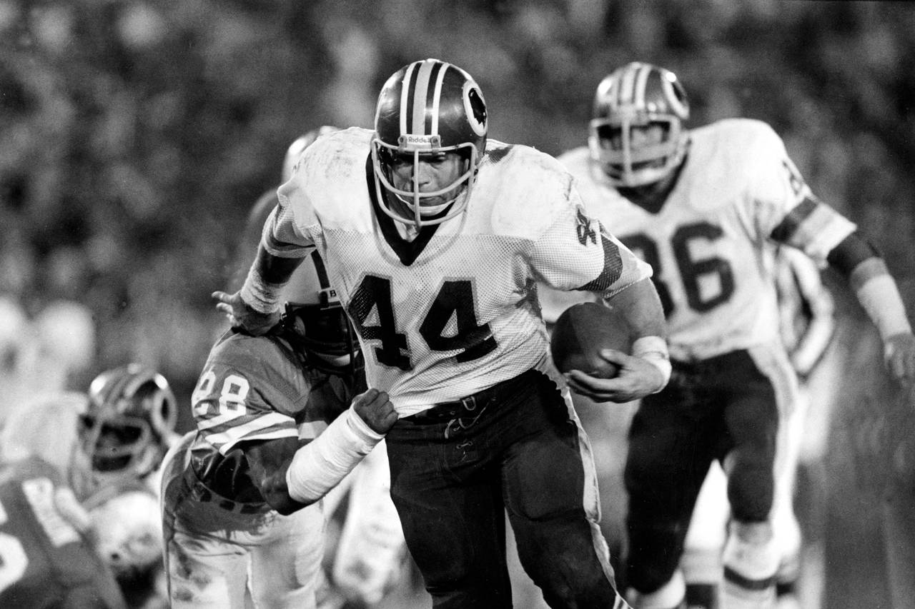 Washington Redskins running back John Riggins (44) hits a stone wall of  Atlanta Falcons as he attempts a run in the game between the Redskins and  the Atlanta Falcons in Washington, Aug.