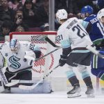 
              Seattle Kraken goalie Chris Driedger (60) makes the save as Vancouver Canucks' Jason Dickinson, back right, attempts to get his stick on the puck during the first period of an NHL hockey game in Vancouver, British Columbia, Monday, Feb. 21, 2022. (Darryl Dyck/The Canadian Press via AP)
            