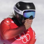 
              Jasmine Flury, of Switzerland holds her face as she arrives in the finish area following a crash earlier during her women's downhill training run at the 2022 Winter Olympics, Monday, Feb. 14, 2022, in the Yanqing district of Beijing. (AP Photo/Luca Bruno)
            