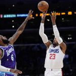 
              Los Angeles Clippers forward Robert Covington, right, shoots as Los Angeles Lakers forward LeBron James defends during the first half of an NBA basketball game Friday, Feb. 25, 2022, in Los Angeles. (AP Photo/Mark J. Terrill)
            