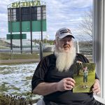
              Sam Smathers holds a photo of Joe Burrow on the porch of his home across the street from the Athens High School football stadium Wednesday, Feb. 9, 2022, in The Plains, Ohio. The stadium is now named in Burrow's honor. Burrow grew up in the village near Athens, Ohio, and played for Smathers on a youth football team before going on to star at the high school and win the Heisman Trophy at LSU. Burrow and the Cincinnati Bengals are scheduled to play the Los Angeles Rams in the NFL football Super Bowl on Sunday. (AP Photo/Mitch Stacy)
            