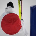 
              Bronze medal finisher Japan's Akito Watabe wraps himself in a flag during a venue ceremony after the cross-country skiing portion of the individual Gundersen large hill/10km competition at the 2022 Winter Olympics, Tuesday, Feb. 15, 2022, in Zhangjiakou, China. (AP Photo/Aaron Favila)
            