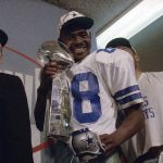 
              FILE - Dallas Cowboys wide receiver Michael Irvin smiles as he holds the Vince Lombardi Trophy the Cowboys won in NFL football's Super Bowl XXVII against the Buffalo Bills in Pasadena, Calif., Jan. 31, 1993. (AP Photo/Rick Bowmer, File)
            