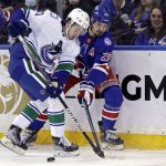 
              New York Rangers left wing Chris Kreider (20) and Vancouver Canucks defenseman Quinn Hughes (43) battle for the puck in the first period of an NHL hockey game Sunday, Feb. 27, 2022, in New York. (AP Photo/Adam Hunger)
            