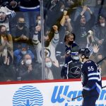 
              Winnipeg Jets' Mark Scheifele (55) and fans celebrate his goal against the Minnesota Wild during the second period of an NHL hockey game Wednesday, Feb. 16, 2022, in Winnipeg, Manitoba. (John Woods/The Canadian Press via AP)
            