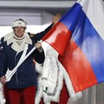 
              FILE - Alexander Zubkov of Russia carries the national flag as he leads the team during the opening ceremony of the 2014 Winter Olympics in Sochi, Russia on Feb. 7, 2014. Doping and other controversies involving Russian athletes have played a significant role at the Games for over a decade. Among those eventually banned was two-time bobsled champion Zubkov. (AP Photo/Mark Humphrey, File)
            