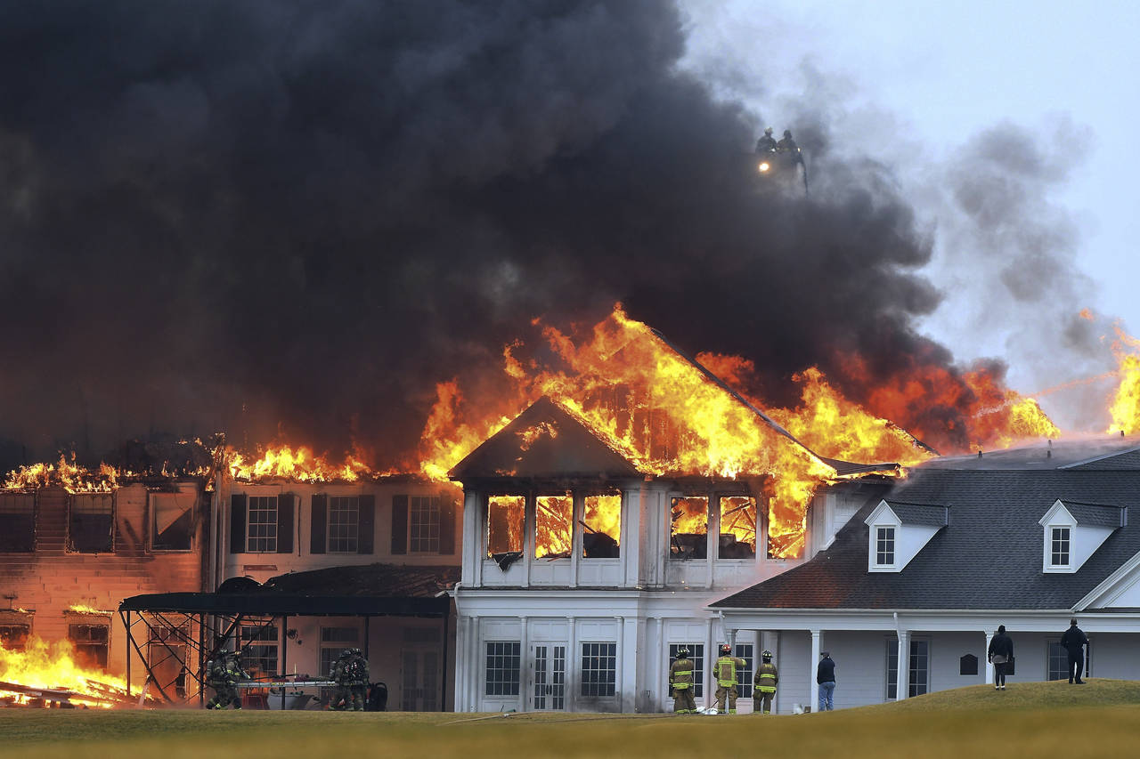 A fire burns at the main building at Oakland Hills Country Club in Bloomfield Township, Mich., on T...