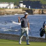 
              Tom Hoge, center, waves while walking up to the 18th green of the Pebble Beach Golf Links during the final round of the AT&T Pebble Beach Pro-Am golf tournament in Pebble Beach, Calif., Sunday, Feb. 6, 2022. Hoge won the tournament. (AP Photo/Eric Risberg)
            