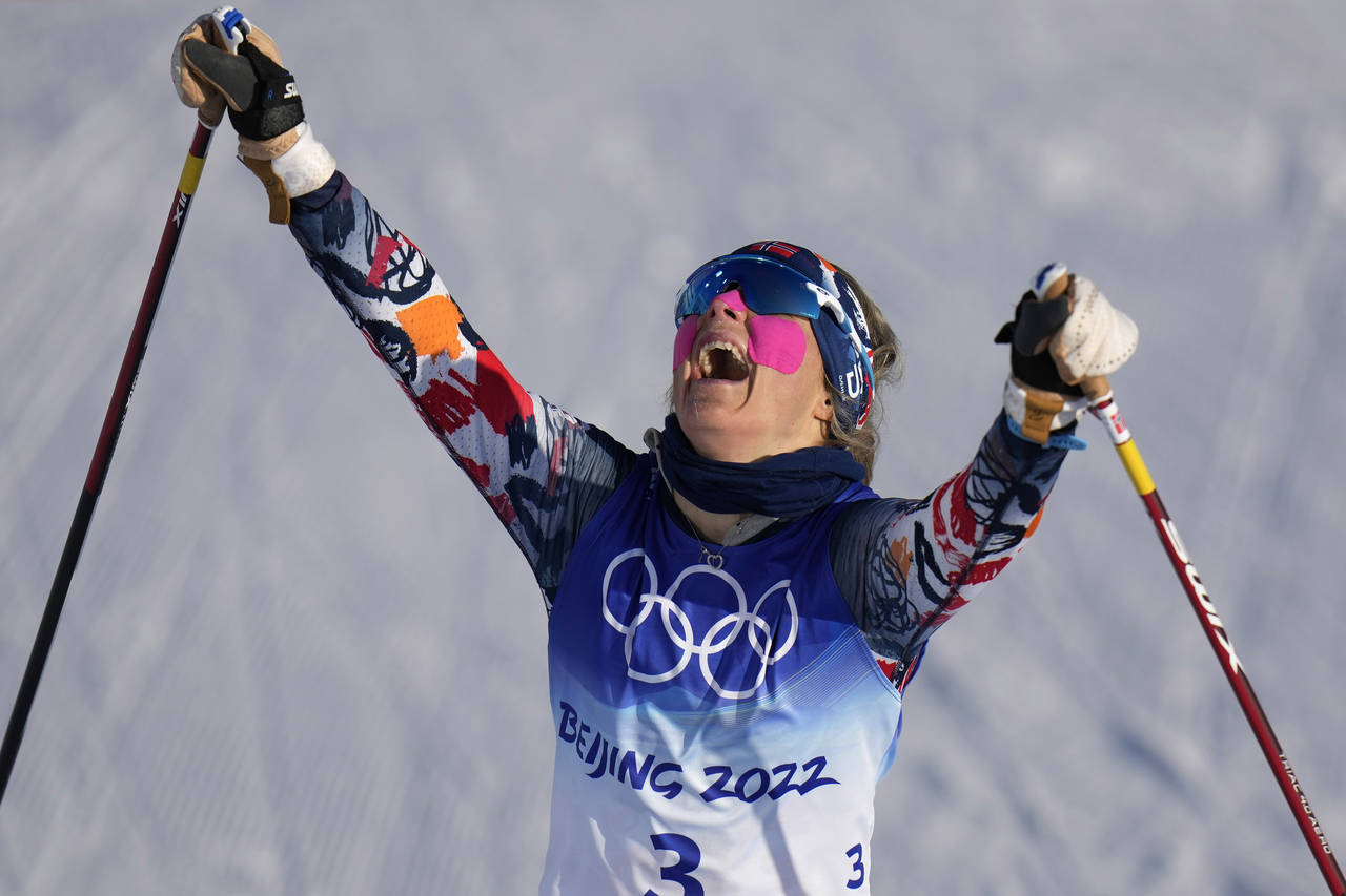 Norway's Therese Johaug celebrates after winning the gold medal during the women's 7.5km + 7.5km Sk...
