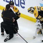 
              Boston Bruins defenseman Urho Vaakanainen, left, is helped after an apparent injury, after he was boarded by Seattle Kraken center Yanni Gourde during the second period of an NHL hockey game, Tuesday, Feb. 1, 2022, in Boston. At right is Boston Bruins goaltender Linus Ullmark (35).(AP Photo/Charles Krupa)
            