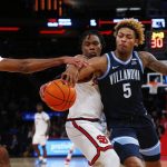 
              Villanova guard Justin Moore (5) competes against St. John's forward Aaron Wheeler, left, and guard Stef Smith for the ball during the second half of an NCAA college basketball game Tuesday, Feb. 8, 2022, in New York. Villanova won 75-69. (AP Photo/John Munson)
            