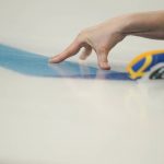 
              Sweden's Sara Mcmanus slides her fingers on the ice after throwing a rock during a women's curling match against Canada at the Beijing Winter Olympics Saturday, Feb. 12, 2022, in Beijing. (AP Photo/Brynn Anderson)
            
