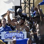 
              Los Angeles Rams defensive lineman Aaron Donald, center, holds up the Vince Lombardi Super Bowl trophy as he celebrates with teammates during the team's victory celebration and parade in Los Angeles, Wednesday, Feb. 16, 2022. The Rams beat the Cincinnati Bengals Sunday in the NFL Super Bowl 56 football game. (AP Photo/Kyusung Gong)
            