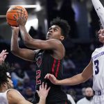 
              Rutgers guard Jalen Miller, center, drives to the basket against Northwestern guard Boo Buie, left, and guard Ty Berry during the first half of an NCAA college basketball game in Evanston, Ill., Tuesday, Feb. 1, 2022. (AP Photo/Nam Y. Huh)
            