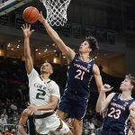 
              Virginia forward Kadin Shedrick (21) blocks a drive to the basket by Miami guard Isaiah Wong (2) during the second half of an NCAA college basketball game, Saturday, Feb. 19, 2022, in Coral Gables, Fla. (AP Photo/Marta Lavandier)
            