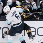 
              Boston Bruins left wing Taylor Hall is checked into the boards by Seattle Kraken defenseman Adam Larsson (6) during the first period of an NHL hockey game, Tuesday, Feb. 1, 2022, in Boston. (AP Photo/Charles Krupa)
            