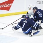 
              Winnipeg Jets goaltender Eric Comrie (1) and Nate Schmidt (88) defend against Seattle Kraken's Carson Soucy (28) during the second period of an NHL hockey game Thursday, Feb. 17, 2022 in Winnipeg, Manitoba. (John Woods/The Canadian Press via AP)
            
