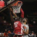 
              Washington State forward Mouhamed Gueye dunks in front of Oregon State forward Ahmad Rand during the second half of an NCAA college basketball game on Monday, Feb. 28, 2022, in Corvallis, Ore. Washington State won 103-97. (AP Photo/Amanda Loman)
            