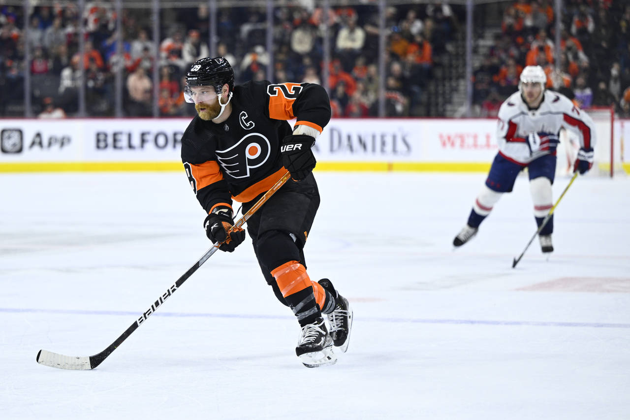 Philadelphia Flyers' Claude Giroux skates up ice with the puck during the second period of an NHL h...