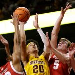 
              Minnesota guard E.J. Stephens (20) shoots between Wisconsin forward Tyler Wahl (5) and guard Chucky Hepburn (23) during the first half of an NCAA college basketball game Wednesday, Feb. 23, 2022, in Minneapolis. (AP Photo/Andy Clayton-King)
            