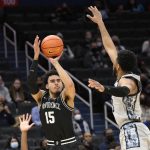 
              Providence forward Justin Minaya (15) shoots against Georgetown guard Donald Carey, right, during the first half of an NCAA college basketball game, Sunday, Feb. 6, 2022, in Washington. (AP Photo/Nick Wass)
            