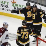 
              Boston Bruins' David Pastrnak, right, celebrates his goal with Patrice Bergeron and Charlie McAvoy (73) as Colorado Avalanche goaltender Darcy Kuemper skates back to his crease during the first period of an NHL hockey game Monday, Feb. 21, 2022, in Boston. (AP Photo/Winslow Townson)
            