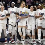 
              Senior Dorka Juhász, center, walks out with her teammates as she is announced during senior day ceremonies before an NCAA college basketball game, Sunday, Feb. 27, 2022, in Storrs, Conn. (AP Photo/Jessica Hill)
            