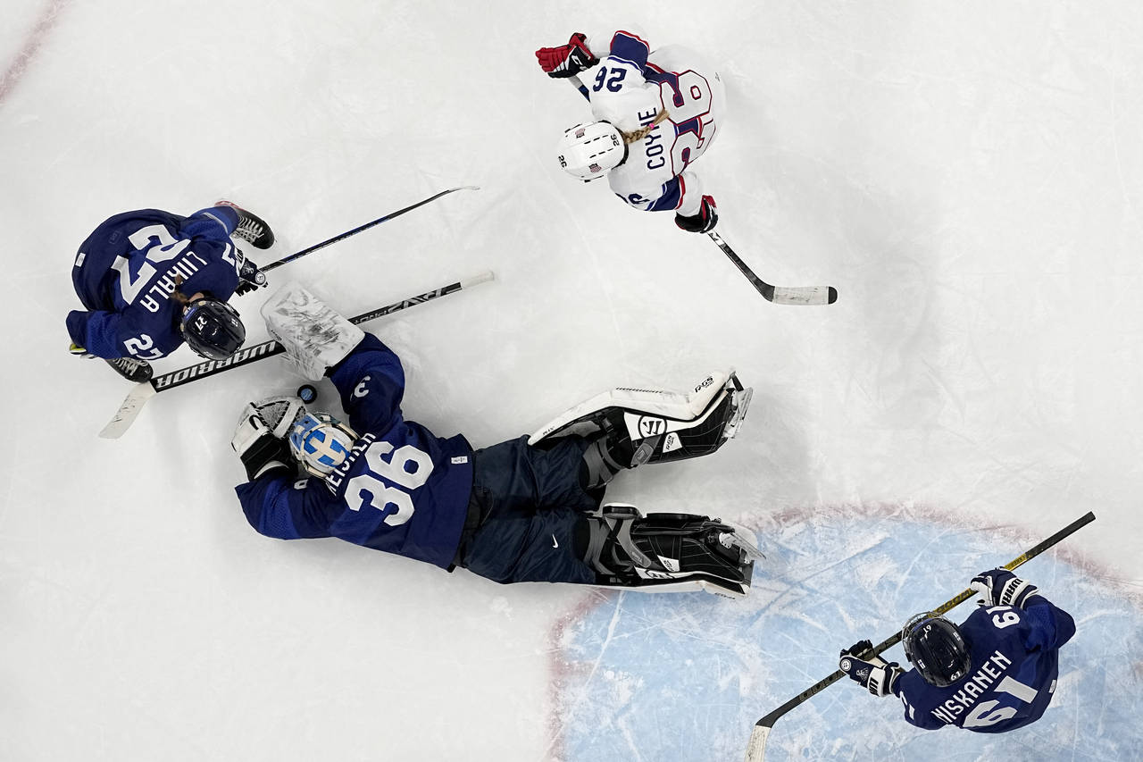 Finland goalkeeper Anni Keisala (36) covers up puck as Julia Liikala (27) and United States' Kendal...