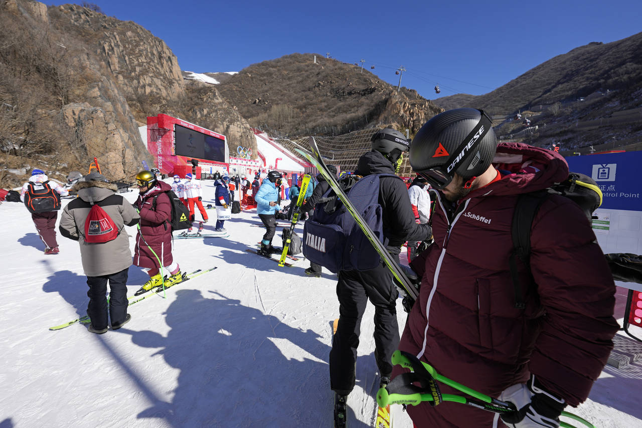 Skiers mingle near the bottom of the course after men's downhill training was cancelled at the 2022...