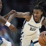 
              Memphis Grizzlies guard Ja Morant, right, brings the ball up court while guarded by Charlotte Hornets guard Terry Rozier, left, during the first half of an NBA basketball game in Charlotte, N.C., Saturday, Feb. 12, 2022. (AP Photo/Jacob Kupferman)
            
