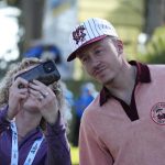 
              Macklemore takes a photo with a fan on the 18th green of the Spyglass Hill Golf Course during the second round of the AT&T Pebble Beach Pro-Am golf tournament in Pebble Beach, Calif., Friday, Feb. 4, 2022. (AP Photo/Tony Avelar)
            