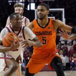 
              Oklahoma guard Umoja Gibson, left, drives past Oklahoma State guard Rondel Walker (5) in overtime of an NCAA college basketball game Saturday, Feb. 26, 2022, in Norman, Okla. (AP Photo/Sue Ogrocki)
            