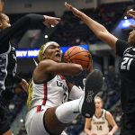 
              Connecticut's Aaliyah Edwards pulls down a rebound between Georgetown's Brianna Scott, left, and Georgetown's Ariel Jenkins, right, in the first half of an NCAA college basketball game, Sunday, Feb. 20, 2022, in Hartford, Conn. (AP Photo/Jessica Hill)
            