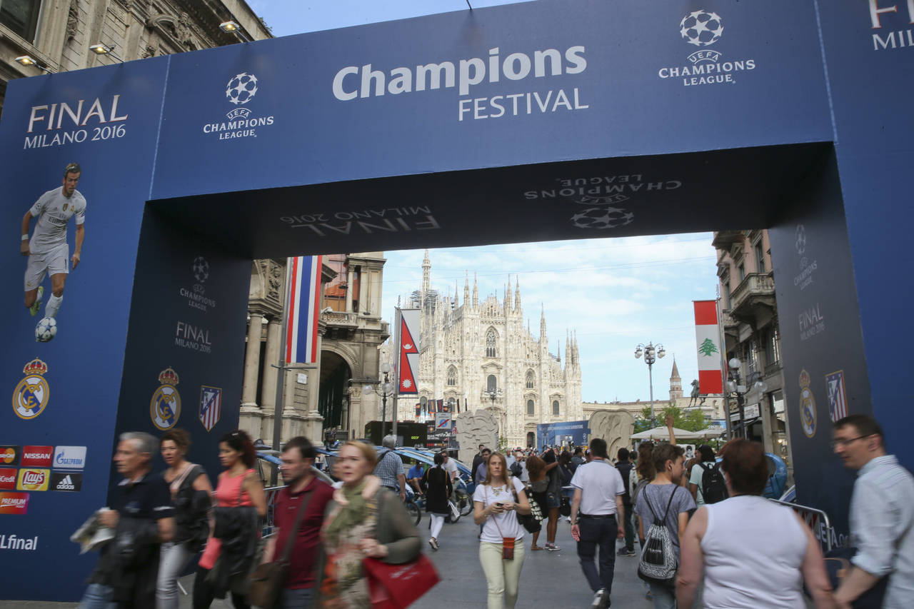 FILE - People walk by the Uefa Champions League fans zone near the Duomo gothic cathedral, in Milan...