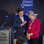 
              Florida Gov. Ron DeSantis, left,  awards the Governor's Medal Of Freedom to Barbara Nicklaus, right, for her contributions and commitment to pediatric health care in the state at the Honda Classic golf tournament Friday, Feb. 25, 2022, in Palm Beach Gardens, Fla. (Greg Lovett/The Palm Beach Post via AP)
            