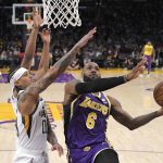 
              Los Angeles Lakers forward LeBron James, right, shoots as Utah Jazz guard Jordan Clarkson, center, and Danuel House Jr. defend during the first half of an NBA basketball game Wednesday, Feb. 16, 2022, in Los Angeles. (AP Photo/Mark J. Terrill)
            