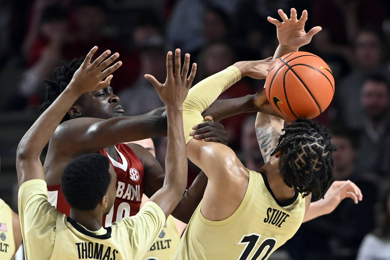 Alabama center Charles Bediako (10) reaches for the ball as he is defended by Vanderbilt guard Trey...