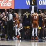 
              Officials break up a small scuffle between West Virginia and Texas during the first half of an NCAA college basketball game in Morgantown, W.Va., Saturday, Feb. 26, 2022. (AP Photo/Kathleen Batten)
            