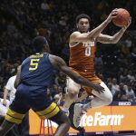 
              Texas forward Timmy Allen (0) is defended by West Virginia forward Dimon Carrigan (5) during the first half of an NCAA college basketball game in Morgantown, W.Va., Saturday, Feb. 26, 2022. (AP Photo/Kathleen Batten)
            