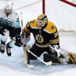 
              Seattle Kraken center Alex Wennberg, left, leaps out of the way of a shot as Boston Bruins goaltender Linus Ullmark (35) drops for the save during the second period of an NHL hockey game, Tuesday, Feb. 1, 2022, in Boston. (AP Photo/Charles Krupa)
            