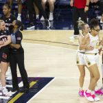 
              An official holds Louisville's Hailey Van Lith (10) while Notre Dame's Dara Mabrey holds teammate Olivia Miles (5), next to Maya Dodson (0) after an altercation on the court during the first half of an NCAA college basketball game Sunday, Feb. 27, 2022, in South Bend, Ind. (AP Photo/Robert Franklin)
            