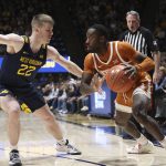 
              Texas guard Courtney Ramey, right, is defended by West Virginia guard Sean McNeil (22) during the first half of an NCAA college basketball game in Morgantown, W.Va., Saturday, Feb. 26, 2022. (AP Photo/Kathleen Batten)
            